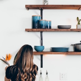 a woman looking at dishes on shelves