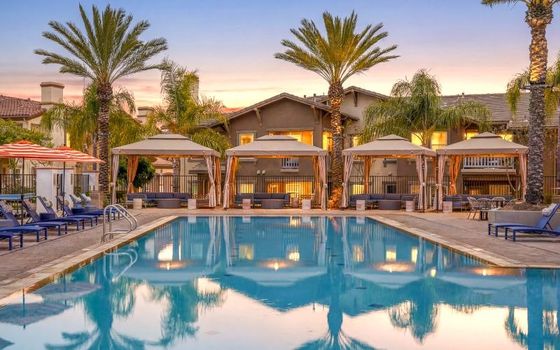 a swimming pool with lounge chairs and palm trees