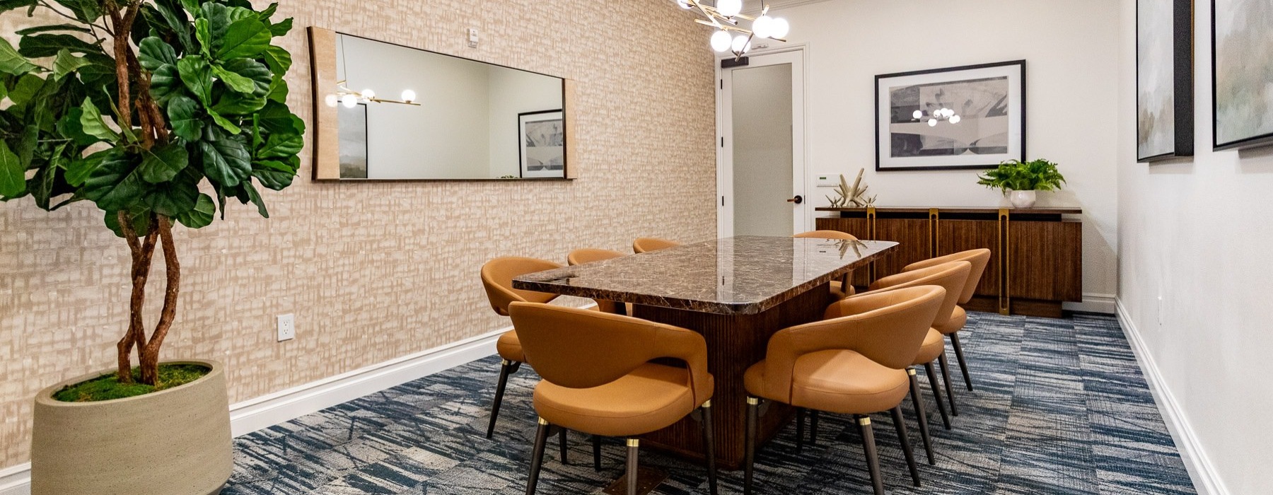 a room with a table, chairs and a tree