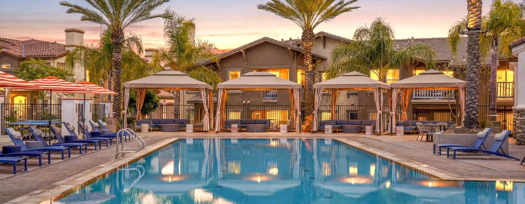 a swimming pool with lounge chairs and palm trees