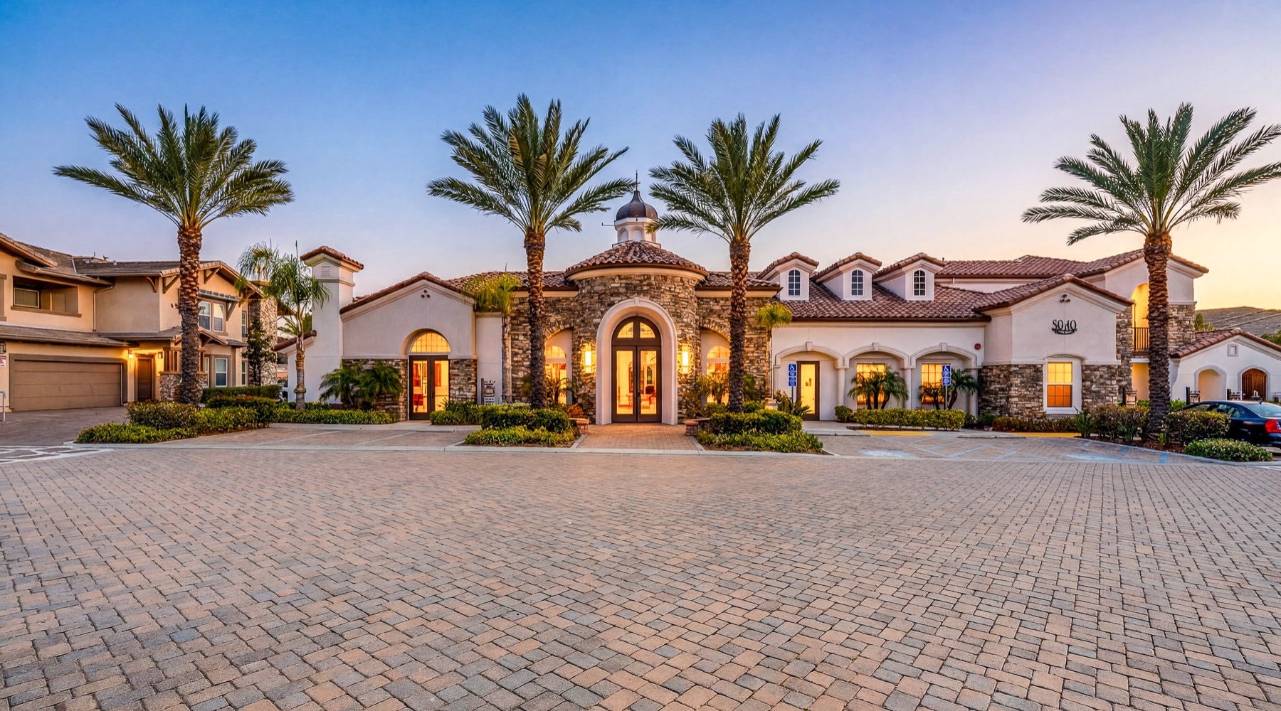 a cobblestone road with palm trees in front of a building